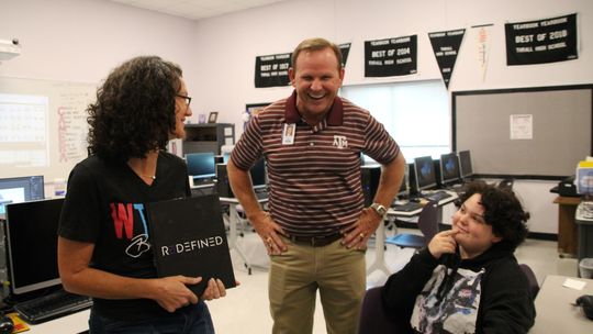 (Left to right) Yearbook Adviser Christina Strnad shows the 2021-2022 Tiger Yearbook Wednesday, Sept. 28 to Superintendent Tommy Hooker and freshman Emma Mendoza at Thrall High School.  