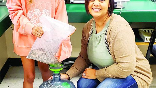 Naomi Pasemann Elementary student, Jayda Leal, deposits her donation to the Pasemann Pennies fund with the assistance of Principal Felicia Gibson. Courtesy photo