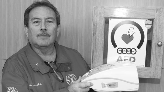 Tim Mikeska holds the AED he donated 16 years ago in memory of his mother, Joy Marshall Mikeska. Photo by Tim Crow