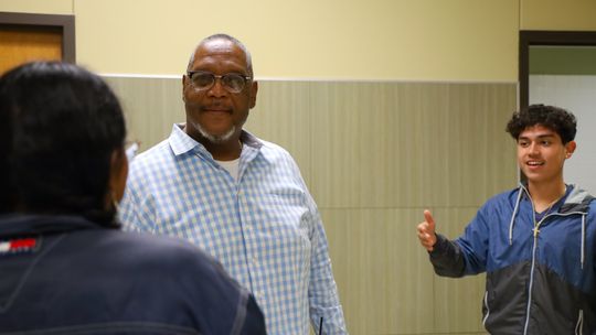 Tommie Garner enjoys a conversation with students while monitoring the hallway at Taylor High School. Photo by Ryan Newsom