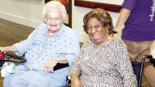 Lessie Givens (right) enjoys visiting with other residents at the S.P.J.S.T. Nursing Home before a presentation in her honor. Photos by Jason Hennington