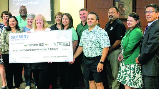 During the Aug. 21 school board meeting, Samsung Austin Semiconductor presented a $110,000 donation. Pictured is the board of trustees, administrative staff and Michele Glaze of Samsung Austin Semiconductor. Photos by Hunter Dworaczyk