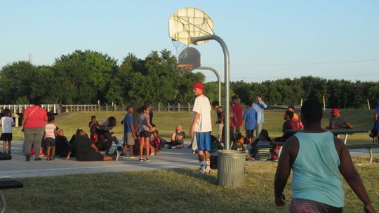 Children of all ages come together to listen to a guest speaker at Midnight Basketball in Fannie Robinson Park in this 2016 photo. File photo