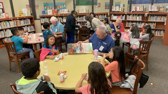 (Clockwise from left) Rotarians Dennis Richter, Cheryl Webster, Kathy Whisenant and George Qualley reading to first grade students at T.H. Johnson Elementary School. Courtesy photo