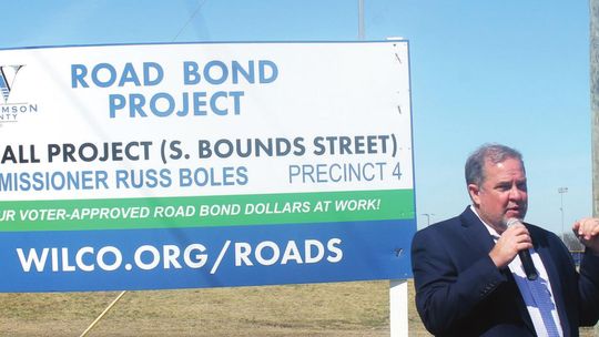 Above: Commissioner Russ Boles addresses residents prior to the ribbon cutting of completed improvements to South Bounds Street in Thrall Feb. 28. Left: Bounds Street runs in front of Thrall Independent School District near the east edge of Thrall. Photos by Fernando Castro