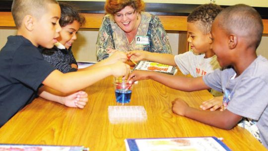 Greater Taylor Chamber of Commerce President Tia Rae Stone joins a group of kindergarteners for a fun science experiment as part of the Taylor ISD Ambassador program in 2016. Photos by Tim Crow