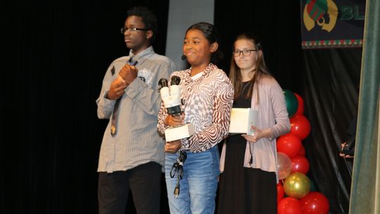 Billie Harrison, Ce’Delia Moore and MacKenzie Maybin recognize the contributions of George Washington Carver, Patricia Bath and Ruane Jeter at the TMS Black History program. Photo by Tim Crow