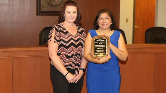 Maria Chavana receives a plaque in honor of her retirement from East Williamson County Cooperative Director Kathryn Wyman.