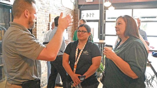 City Manager Brian LaBorde talks with Taylor Police Department Support Services Administrator Claudia Parisella, center, and Communications Supervisor Theresa Briones during Coffee with a Cop on May 10 at Good Strangers. Photo by Kendra Maness