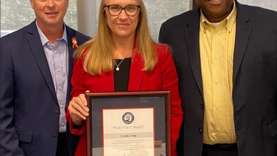 Williamson County Precinct 2 Commissioner Cynthia Long (middle) celebrates being recipient of the 2022 Texas Department of Transportation (TxDOT) Road Hand Award. Also pictured are (left) Tucker Ferguson, TxDOT Austin district engineer, and Ashby Johnson, CAMPO executive director. Courtesy...