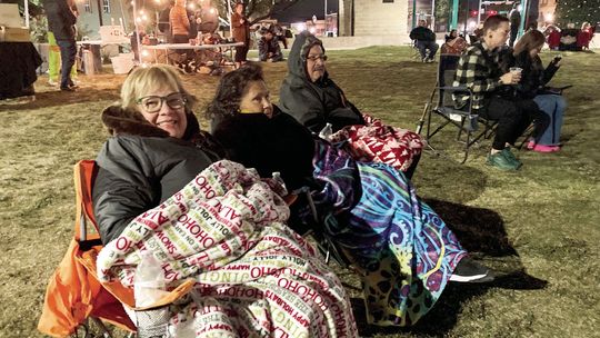 (From left) Dora Gomez, Estella De La Rosa and Joe De La Rosa keep warm as they enjoy the musical stylings of R &amp; B band Honey Made Nov. 17 at Heritage Square Park. Photos by Nicole Lessin