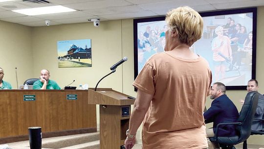 Stacy Stork, a member of a citizens compensation committee, protests the City Council’s split vote to increase their own pay to $1,000 per month and $1,500 for the mayor at the regular meeting July 27. Photo by Nicole Lessin