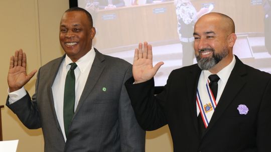 Gerald Anderson (left) and Robert Garcia smile as they are sworn-in to continue their service as city councilmen for Districts 1 and 4, respectively. 