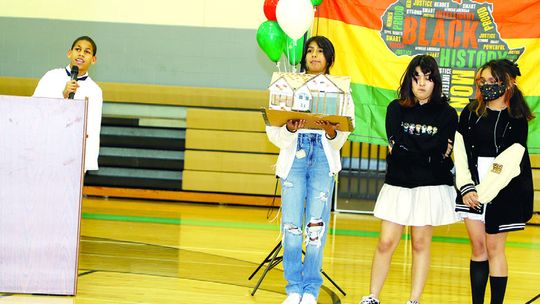 Rodolphe Rochez honors Dr. James L. Dickey with a tribute to his life and career while classmates display a model of Dr. Dickey’s home in Taylor. See an additional photo from the event on page 2 E-edition. Photos by Tim Crow