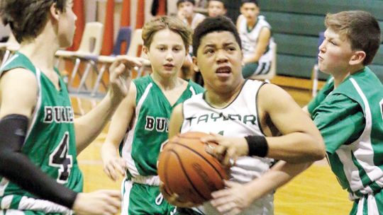 Yonair Guzman fights through defenders and takes the ball to the bucket in the A team’s final home game of the season. Photos by Jason Hennington