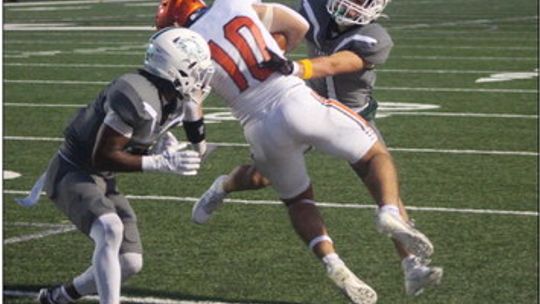 Taylor High School varsity football junior cornerback Ethan Flagg (left) and senior safety Devin Valdez (right) combine to tackle an opposing receiver on Sept. 15 during the Ducks’ 49-19 victory at home vs. Smithville High School. Photo by Andrew Salmi