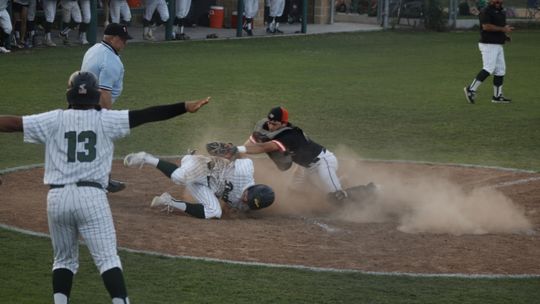 Ashton Vega stirs up the dust as he crosses home plate in Friday night’s bi-district win for the Ducks over Smithville.