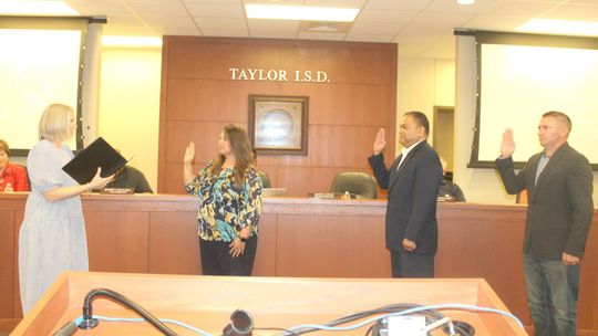 Vicki Roth (left) administers the oath of office for returning and new Taylor ISD board members Cheryl Carter, Marco Ortiz and Joseph Meller during the board’s meeting in Taylor May 16.