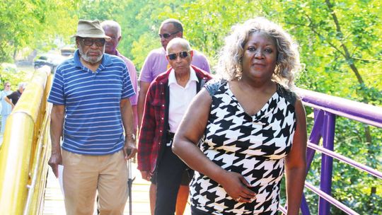 Doris Corely leads other former O.L. Price students Raymond White Jr., Ernest Rector, Rev. James Davis and current Mayor Pro Tem Gerald Anderson across the Dickey bridge June 27 in Taylor. Photos by Jason Hennington