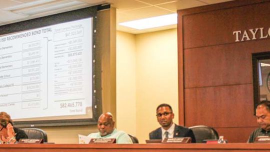 The Taylor ISD Superintendent Devin Padavil (middle) gives specific details to the board of trustees about the bond.