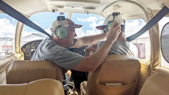 Volunteer Pilot Scott Bounds adjusts Emiliano Gonzalez’s headsets as he prepares to fly an airplane at the Flying Vikings event Sept. 17. Courtesy photos