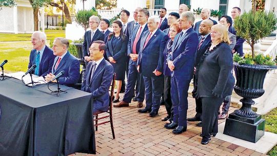 Gov. Greg Abbott (sitting, centered) begins a press conference to announce the Samsung investment in Taylor at the Governor’s Mansion in Austin Nov. 23, 2021. Photo by Jason Hennington