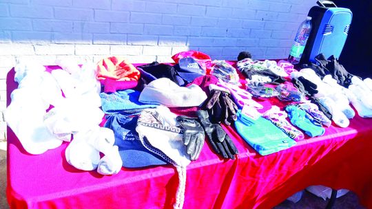 Assorted gloves, hats and other cold-weather gear is displayed at a Winter Coat Give Away Dec. 17, sponsored by the local restaurant Seed to Soul Food and 10,000 Fearless First Responders. Photo by Nicole Lessin