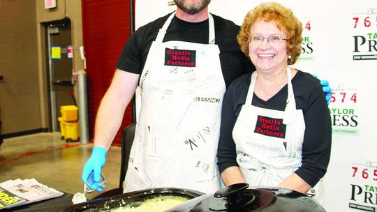 Granite Media Partner owner and CEO Daniel Philhower serves biscuits and gravy with mother-in-law Lynette Hunt during the ‘Food Dudes’ fundraiser to assist Taylor Independent School District classroom needs. Photo by Nicole Lessin