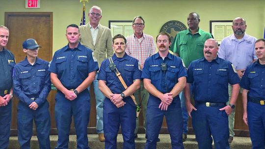 Chief Daniel Baum (right) talks about the heroic efforts of Taylor Fire Department firefighters who worked as a team to complete a dramatic ladder rescue and extinguish a dangerous fire at the Burnett Place Apartments June 5, including Assistant Chief Robert Copeland (left), Lt. Eric Engel...