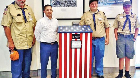 Elliott Koncaba and others stand beside one of the flag retirement boxes throughout Hutto. Courtesy photo / City of Hutto