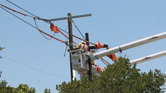 A utility worker works on a power line pole on Lake Drive in Taylor July 24, 2020.