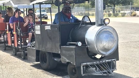 JC Callis is the engineer for his Kiddie Express train that gives free rides through Coupland. Photos by Susan Garry