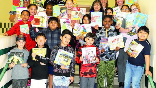 Employees at FedEx Ground Pflugerville held a book drive, donating 366 books to Taylor ISD. These books will be distributed to elementary students to support summer reading. FedEx representatives Jean Tate and Jabari Williams are shown presenting the books to Naomi Pasemann Elementary stud...