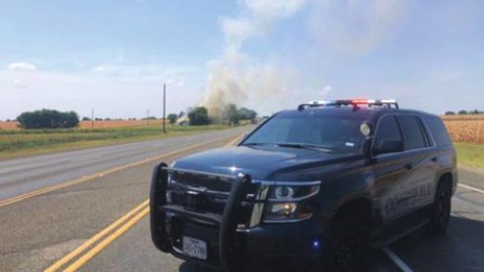 A Williamson County Precinct 4 Constable vehicle helps block traffic as a fire rages on Main Street between Chandler Road and FM 1331 in Taylor June 30. Facebook / Williamson County Constable Precinct 4