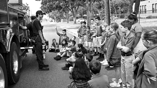 Firefighter Colton Brock shows students a tool that firefighters sometimes use during emergencies.