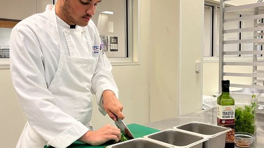 Student Jacob Johnson, of Pflugerville, chops parsley in a kitchen in Texas State Technical College’s Culinary Arts program at the East Williamson County campus.  