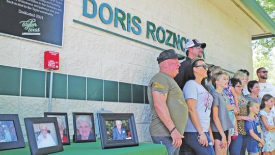 LEFT: The extended family of Doris Roznovak, shown in framed photographs on the table, celebrate the renaming of Murphy Park’s pool facility to the Doris Roznovak Aquatic Center in Taylor May 28.