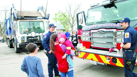 Declan Haussmann, 2, smiles after getting to see a ladder truck up close with mom Ashley Reynolds and big brother Stacy Davis, 11. Photos by Nicole Lessin