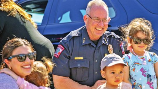 Hutto Police Chief James Stuart stops for photos with children who are between climbing in and out of vehicles.