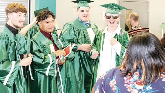 Hunter Crump (far right), showing the smile he was known for, poses for a photo at his graduation from Taylor High School in 2022. Photo by Tim Crow