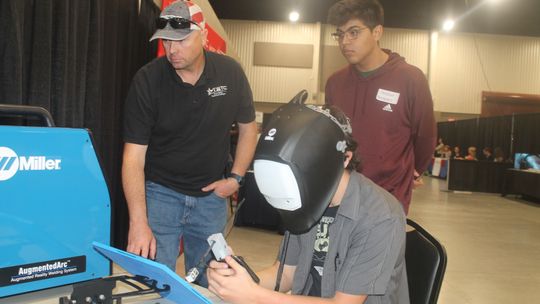 Robert Peller sits at the Texas State Technical College table alongside Christian Hernandez (right) and TSTC instructor Steven Coody at the Trades Day Career Fair at the Williamson County Expo Center in Taylor March 2. BELOW: A reverse view of the station is shown.