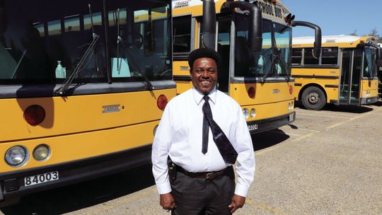 Taylor ISD Transportation Director, Carl Caldwell, is shown with four of the five older buses that will be replaced, thanks to a grant. Photo by Tim Crow