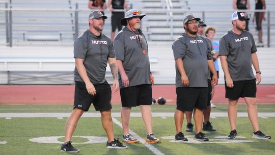 Hutto varsity football head coach Will Compton (second from the left) and his coaching staff look on during the Hippos' road scrimmage vs. Vandegrift. photo by Larry Pelchat P 