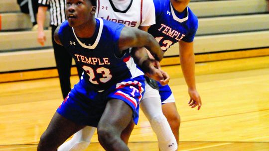 Hippos junior Zachary Hicks fighting off two defenders attempting to haul in a rebound. Photo by Larry Pelchat