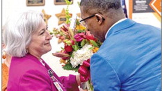 Hutto ISD board member James Matlock gives Superintendent Celina Estrada Thomas her flowers to celebrate her five years with the district.