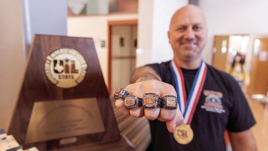 Hutto High School robotics coach Andrew Haub shows off the five state championship rings his teams have earned since 2016. Courtesy photo