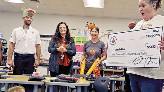 Nicole Pina is surprised by members of the Hutto Education Foundation when they presented her with a $5,412 check for Marvelous Math Materials.