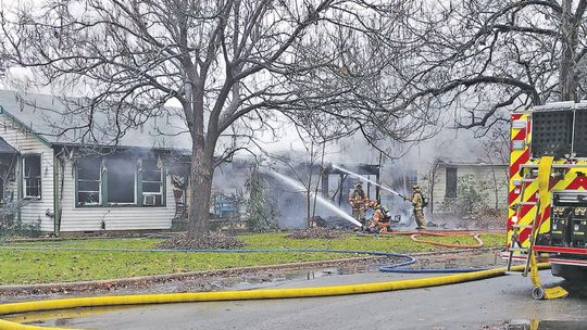 Firefighters extinguish a house fire Dec. 19 at the corner of Fisher and Kimbro Streets. Photo by Jason Hennington