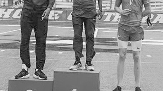 Jarvis Anderson (center) standing in the first place spot on the podium after winning the triple jump event. Courtesy Photo