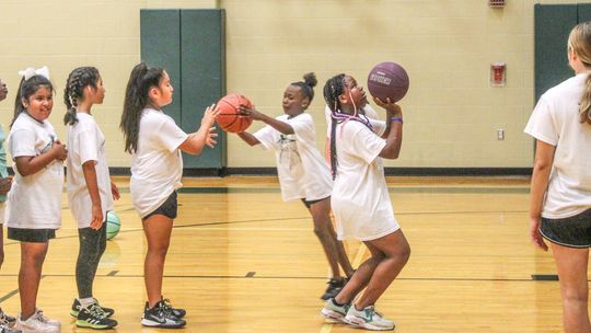 A group of young campers waits in line while playing a game of knockout on June 8 during the Lady Ducks Youth Basketball Camp.